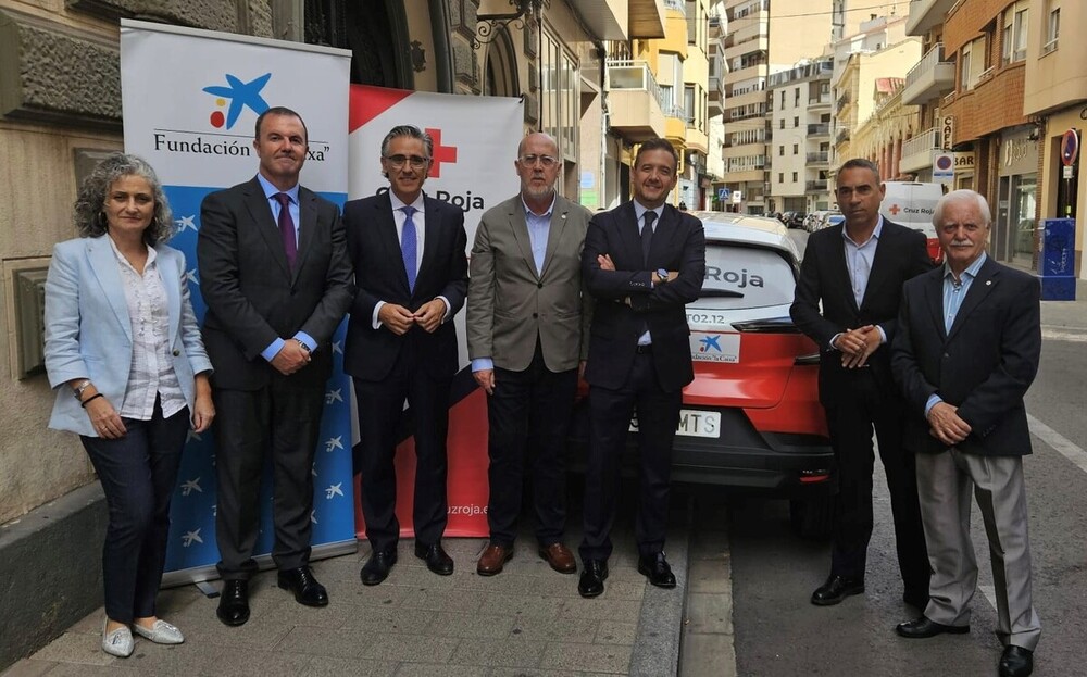 Representantes de CaixaBank y Cruz Roja, junto al vehículo adquirido.