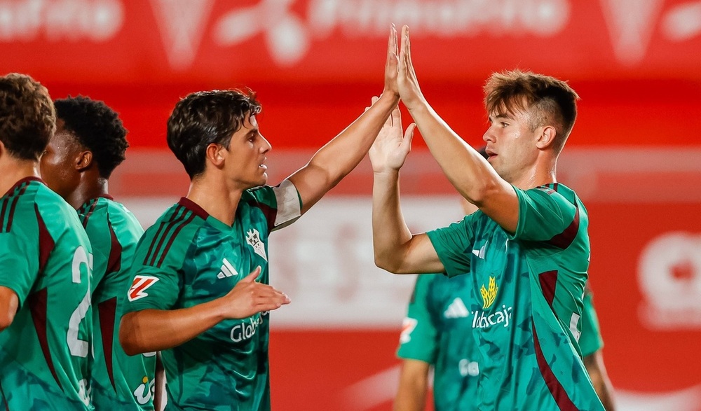 Riki felicita al canterano Marcos Moreno por su gol.